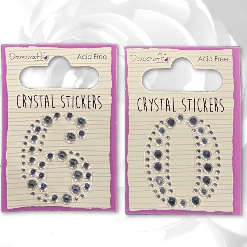 The Printable Heaven Dovecraft Crystal Numbers - 60 (DCST040/044) pack includes self-adhesive crystal numbers 6 and 0 on lined backing cards with purple borders—ideal embellishments for birthday cards.