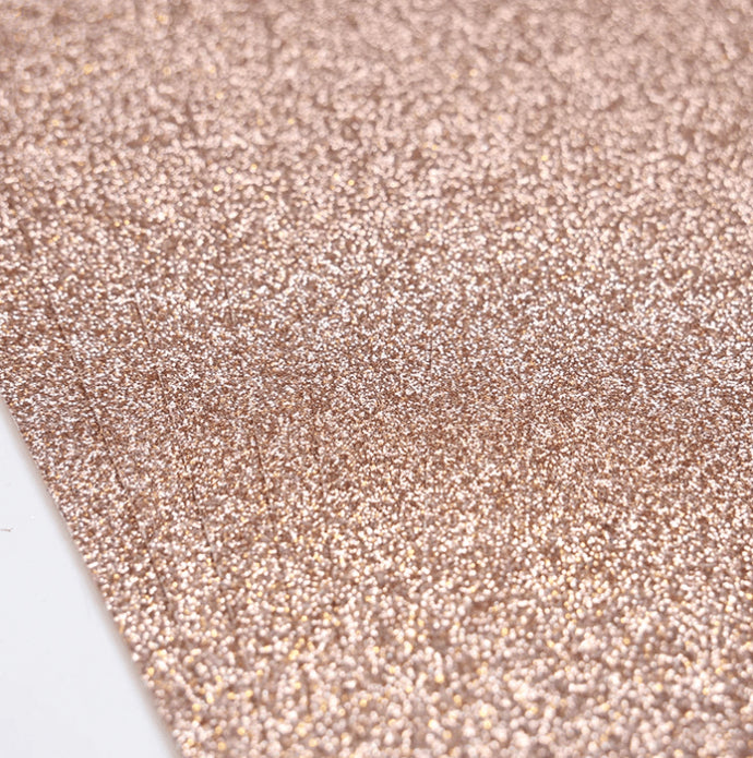 A close-up of Printable Heaven’s Dovecraft A4 Double Sided Glitter Card in Rose Gold (350gsm, 6 Sheets) shows its sparkling, textured surface reflecting light for a shimmery metallic look on both sides.
