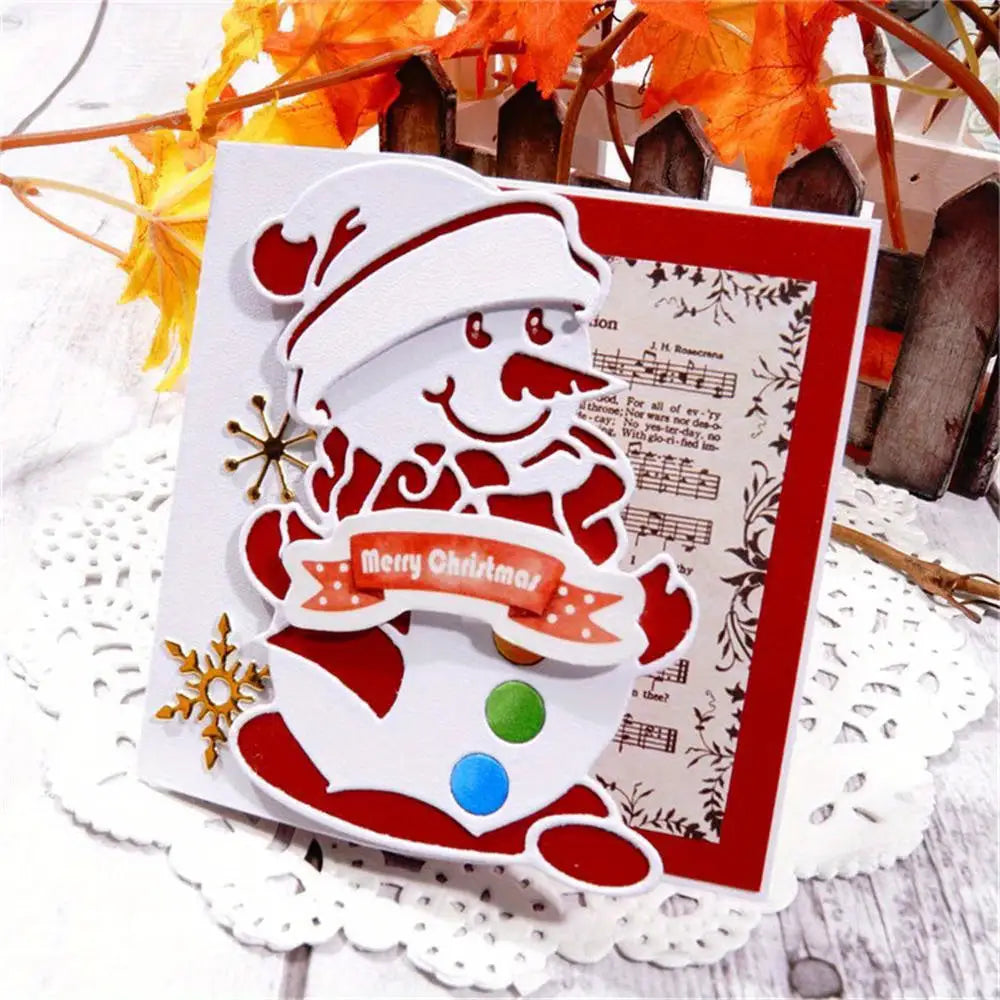 Sure! Here’s a rewritten version using your product data: A handmade Christmas card created with the Printable Heaven Snowman Christmas Cutting Die (1 PC) (P140), featuring a cheerful snowman in a hat and scarf holding a ‘Merry Christmas’ banner, set against a musical sheet and snowflake background. Autumn leaves and a wooden fence complete the wintry scene, making this card ideal for fans of winter-themed paper crafts.