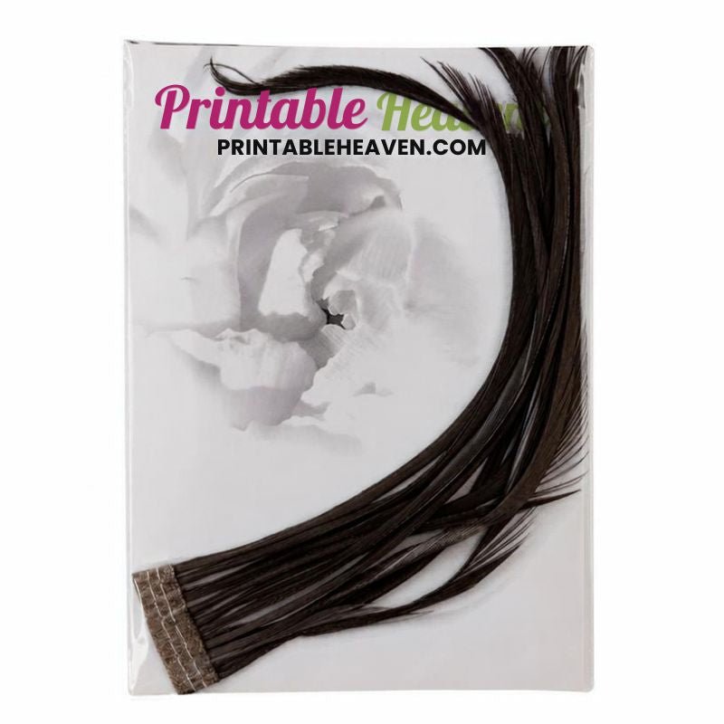 A bundle of long, dark grey striped Goose Biot Feathers in Grey attached to a base strip, packaged in a clear plastic sleeve.