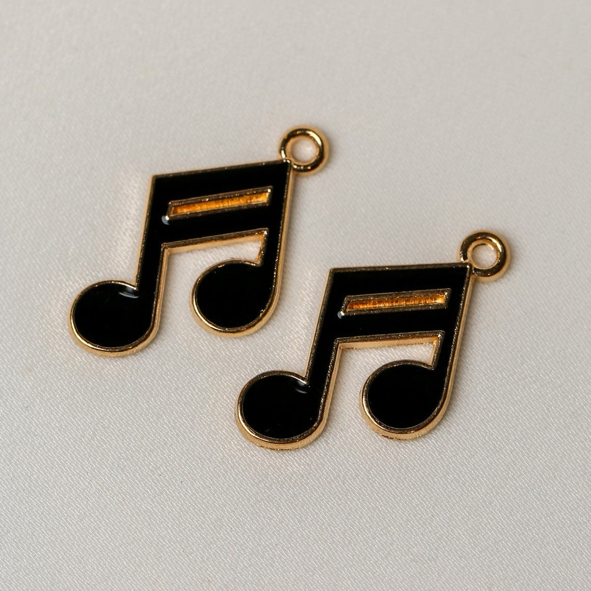 Two Semiquavers Music Note Metal Charms (2pcs) (MLB-120), featuring gold-toned music notes with black enamel fill and small loops for hanging.