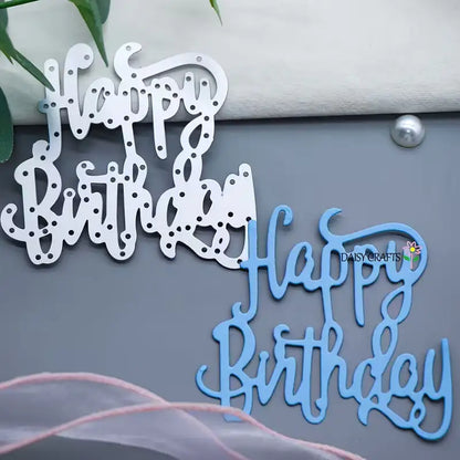Elevate your birthday cards or scrapbooking projects with this versatile “Happy Birthday Sentiment Cutting Die (1 PC) (W243)” from Printable Heaven. The cutting die features two styles: a white cutout with intricate holes and a solid blue version stamped with the DaisyCrafts flower logo. Both are displayed on a sleek gray surface, accompanied by pieces of fabric and green leaves for added inspiration.