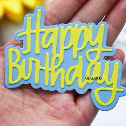 A hand displays a blue and yellow “Happy Birthday” sign crafted with layered material and elegant cursive lettering, perfect for paper-crafting projects or birthday card making using the Printable Heaven Happy Birthday Sentiment Cutting Die (2 PCS) (W101).