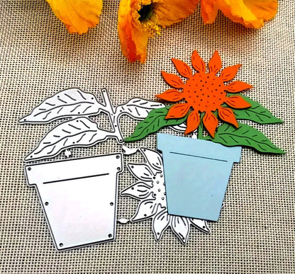 Elevate your next paper crafts project with the Sunflower & Pot Plant Cutting Die (3 PCS) (F036) from Printable Heaven—metal dies featuring a potted sunflower, including both colored and plain designs, displayed on burlap alongside orange flower petals for charming botanical embellishments.