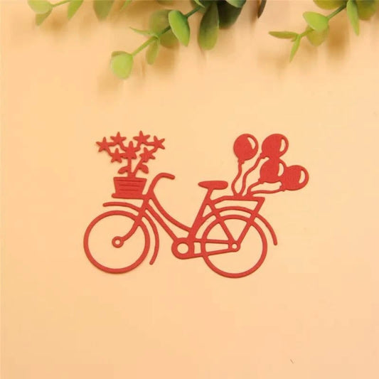 A charming scene showcasing the Printable Heaven Bicycle with Balloons & Gifts Cutting Die (1 PC) (D104)—a red outline of a bicycle adorned with a potted plant at the front and balloons at the back, set against a light background with green leaves overhead—perfect for adding delightful embellishments to your paper crafting projects.