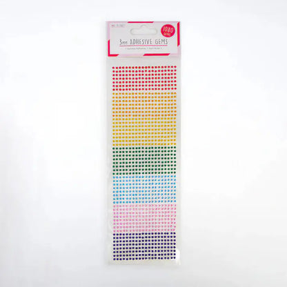 The "Love to Craft 3mm Gems - Rainbow (LCDOT037A)" includes 1080 self-adhesive gems arranged by color—red, orange, yellow, green, blue, and purple—perfect for papercraft projects. The top label reads "3mm Adhesive Gems, 1080 pcs.