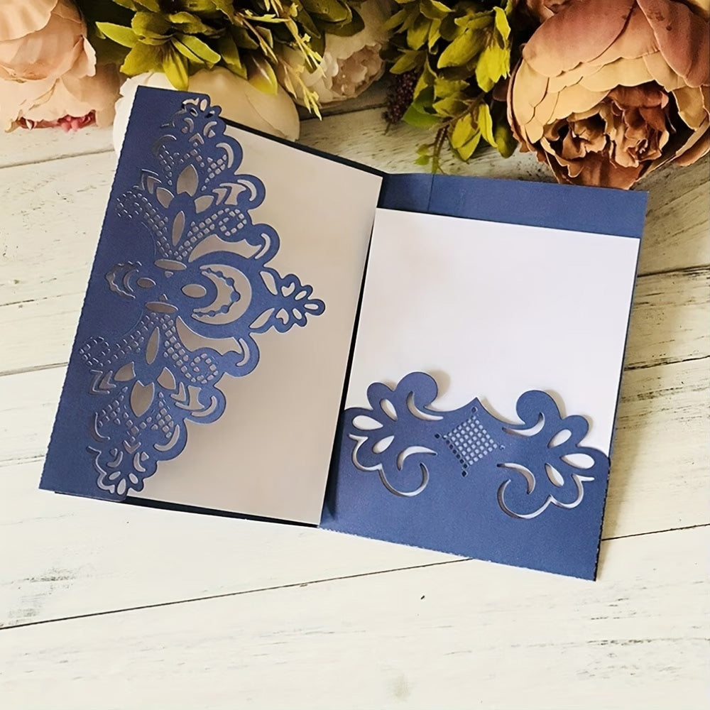 An elegant papercrafting project features a blue greeting card with an intricate floral pattern inspired by the Printable Heaven Filigree Corner Cutting Die (1 PC) (B007), shown open on a white wooden surface and surrounded by artificial flowers—the ideal finishing touch for creative cardmaking.