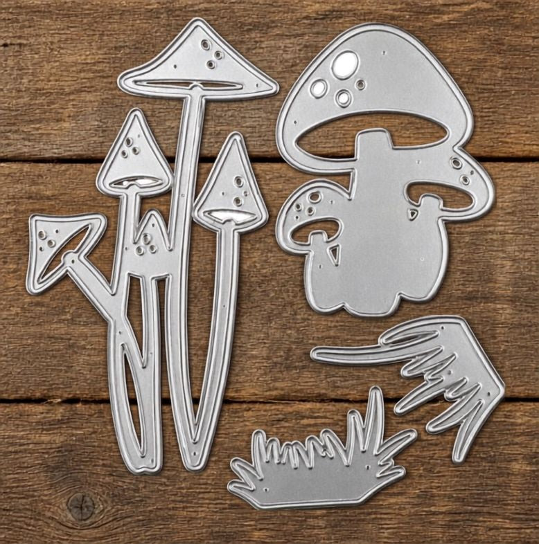 Four silver metal dies from the Printable Heaven Woodland Toadstool and Mushroom Cutting Die set (4 PCS) (SP103) are arranged on a wooden background. Ideal for nature-inspired crafts, these dies feature intricate cutout details for added texture and design, making them a perfect addition to any woodland die collection.