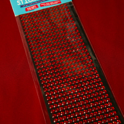 A pack of 6mm Red Crystal Sticky Gems by Printable Heaven, arranged in neat rows, perfect for craft projects, displayed on a red background.