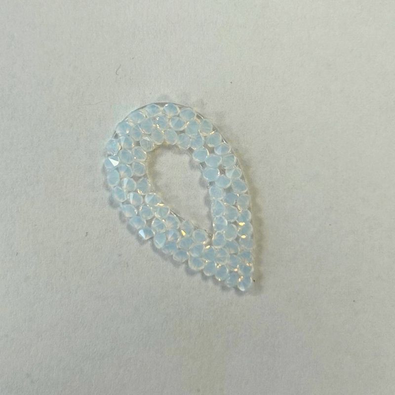 Swarovski Self-Adhesive Pearlescent Teardrop in Opal teardrop-shaped embellishment made of small, iridescent, pale blue-tinted stones.
