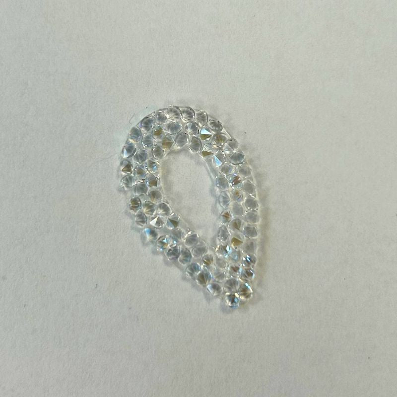 A Swarovski Self-Adhesive Pearlescent Teardrop in Moonlight, a teardrop-shaped embellishment made of small, faceted adhesive crystals.