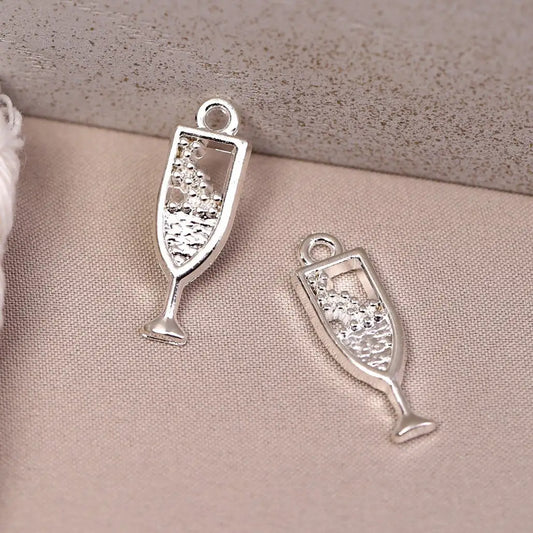 Two silver-toned Champagne Glass Metal Charms (8pcs) (MLB-110) shaped like flutes with bubbles inside.