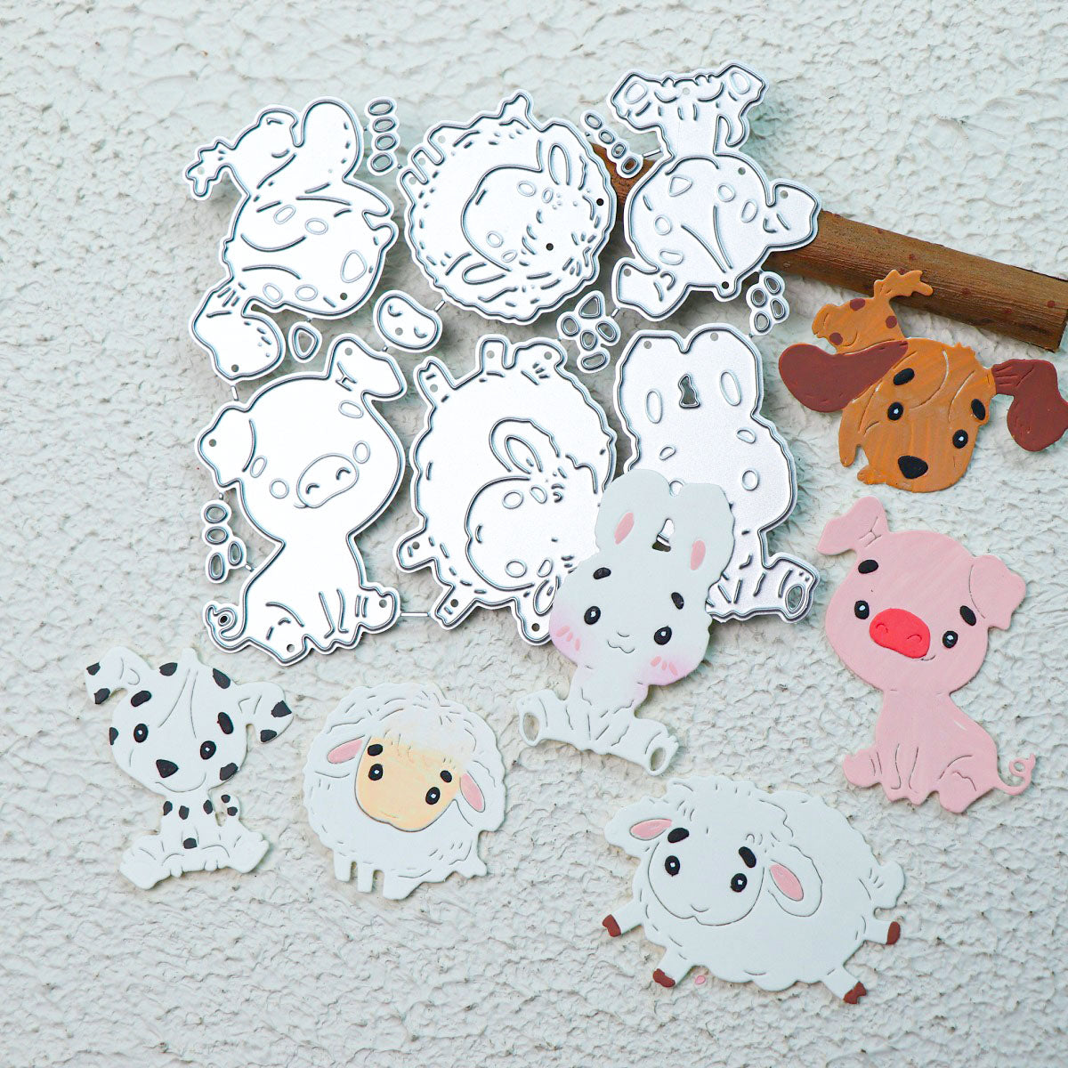 Metal stencil and vibrant paper cutouts featuring adorable animals—including a dog, lamb, bunny, pig, and dalmatian—created with the Printable Heaven Cute Kawaii Animal Character Cutting Die Set (6 pcs) (A057) are artfully arranged on a textured white surface. Perfect for paper crafting with metal cutting dies from Printable Heaven, these charming designs bring whimsy to any creative project.
