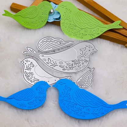Showcased on pristine white fur, two green and blue paper birds adorned with floral patterns and a striking 3D wing design are crafted using the Decorative Bird Cutting Die Set – 3D Wing Design (4 PCS) (SP126) by Printable Heaven—perfect inspiration for your next creative papercraft project.