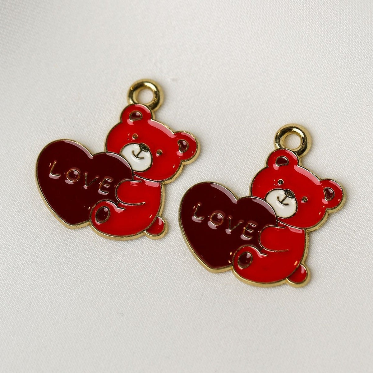 Valentine’s Teddy Bear Metal Charms (2pcs) (MLB-114): two metal teddy bear charms, each holding a red heart embossed with the word LOVE.