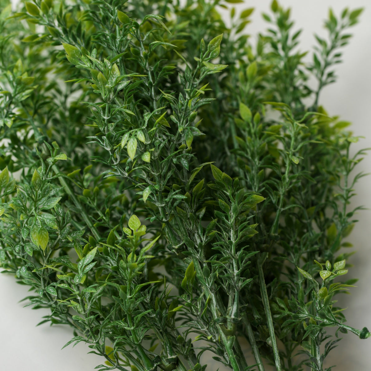 A cluster of Printable Heaven Faux Leaf Sprigs featuring green leaves on slender 18.5″ stems.