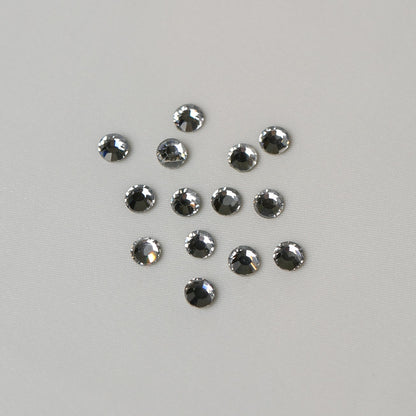 Twelve small, round, faceted SS16 Hot Fix Silver Foiled AB Crystals arranged in a loose cluster on a light grey background.