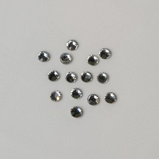Twelve small, round, faceted SS16 Hot Fix Silver Foiled AB Crystals arranged in a loose cluster on a light grey background.