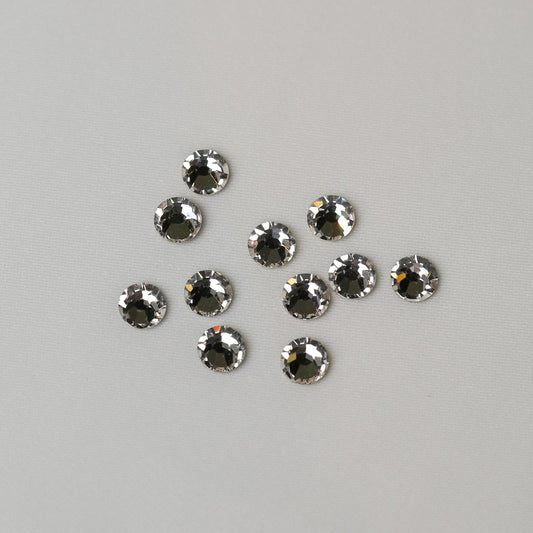 Ten circular SS20 Hot Fix Silver Foiled Crystals by Printable Heaven arranged on a plain light background.