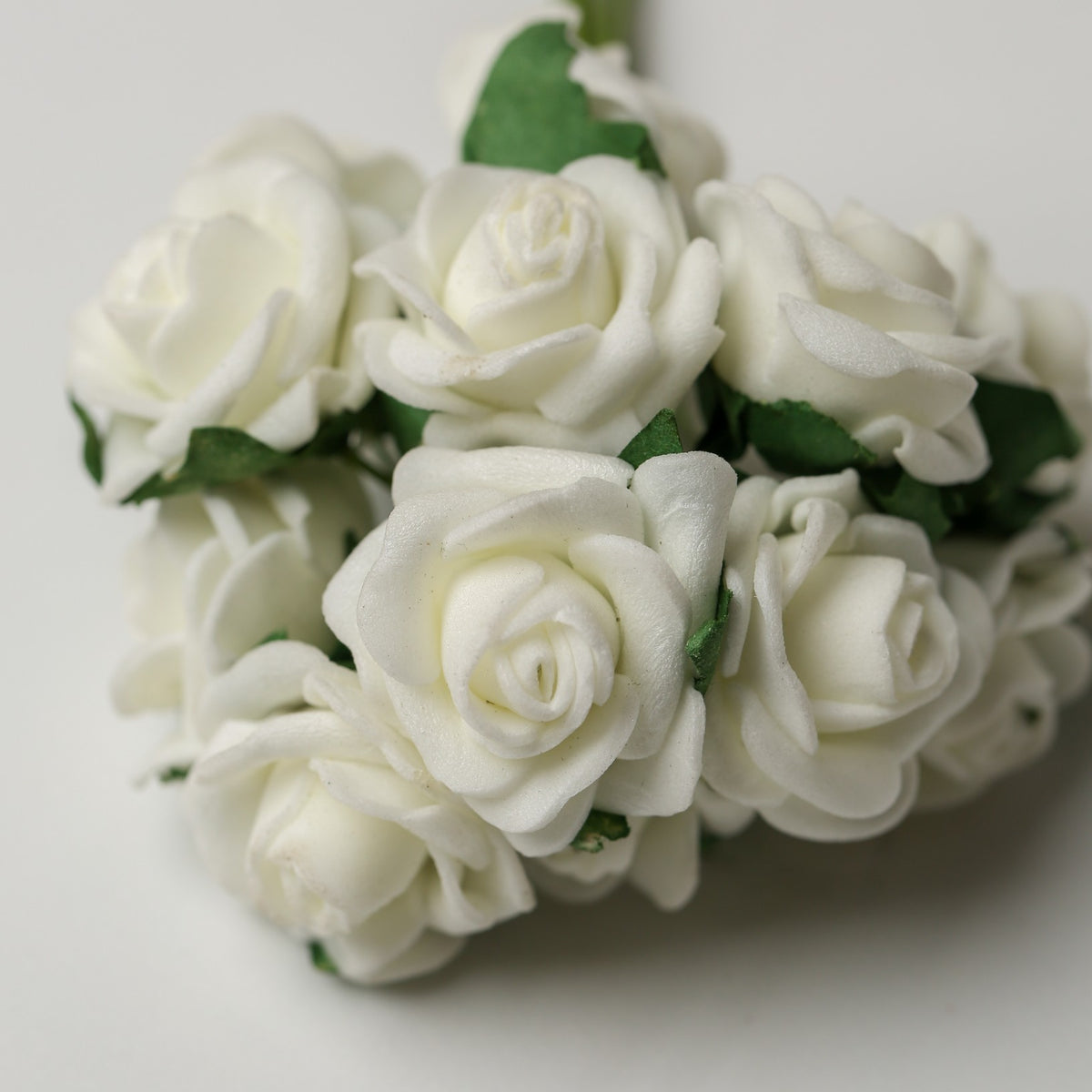 A small bunch of Printable Heaven Small Foam Rose Bunch in Ivory (1″ Wide) featuring ivory foam roses with green leaves.