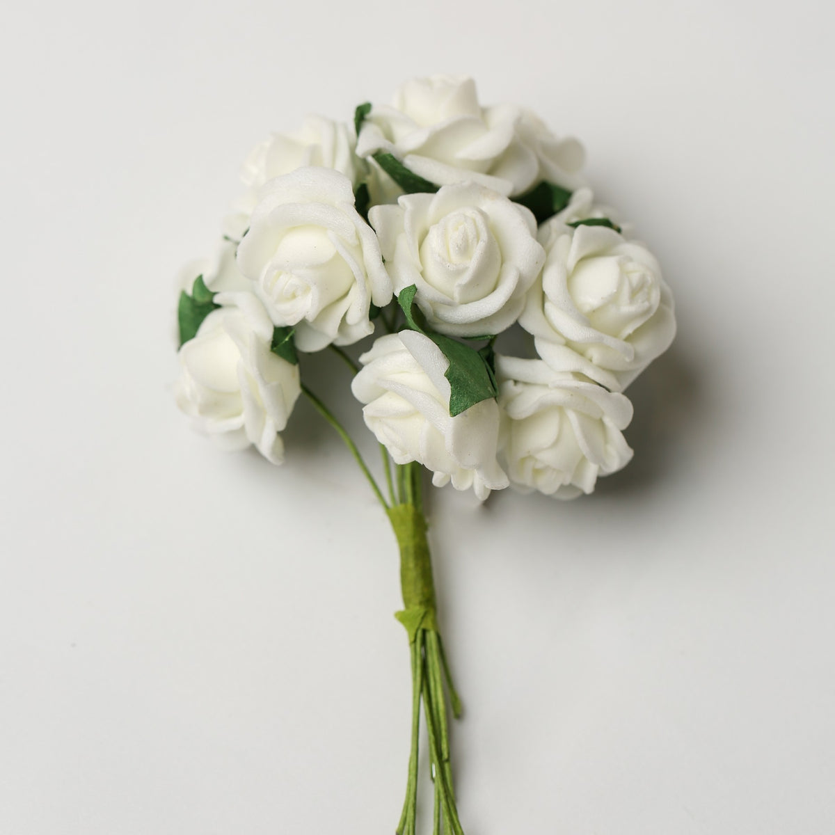 A small bunch of Printable Heaven Small Foam Rose Bunch in Ivory (1″ Wide) featuring ivory foam roses with green leaves and stems.
