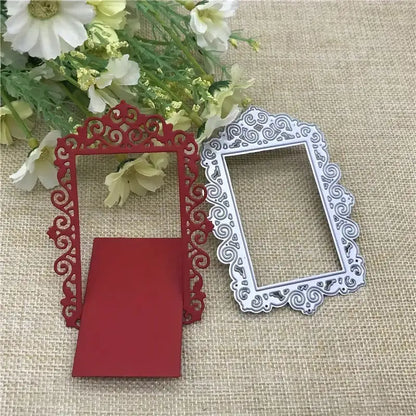 Two ornate rectangular frames, one red and one silver, showcasing intricate scrollwork designs crafted with the Printable Heaven Ornate Decorative Frame Cutting Die (1 PC) (T048), are arranged on a burlap surface beside a bouquet of white and yellow flowers. Perfect as cardmaking embellishments, these elegant frames bring an added touch of sophistication to any creative project.