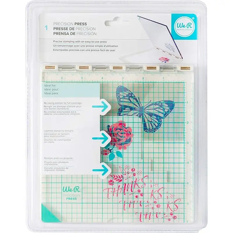 Printable Heaven We R Memory Keepers WR Tool Precision Press (WR663007) comes packaged with a clear grid plate adorned with floral and butterfly designs, perfect for layered stamping. Blue instructional arrows are included, and the top label prominently displays the product name along with a multilingual description.