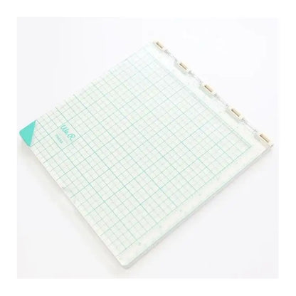 A square crafting tool with a clear grid surface, teal corner detail, and a top hinge with tabs—like the Printable Heaven We R Memory Keepers WR Tool Precision Press (WR663007)—is perfect for precise alignment in arts and crafts projects.